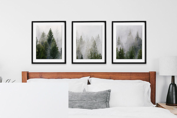 three framed photos above a bed with a white mat and black frame